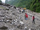 03 Landslide On Arniko Highway Just Before Kodari About 8km before the Nepalese border town of Kodari in July 2006, the same landslide that stopped us in July 2005 stopped us again. This time, the local porters were very organized, and after about an hour we were on our way again for the final few kilometres, Me-thinks this landslide is good for the local economy.